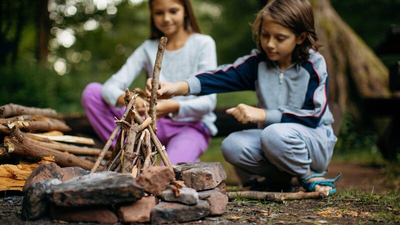 Bambine che accendono un fuoco